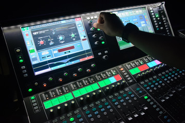 hand of sound engineer on the sound mixer,Sound engineer working at mixing panel in the boutique recording in pub