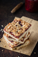 Homemade shortcrust raspberry pie with crumble on dark stone concrete table background. Jam Bars Snack Food