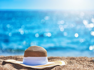 Bonnet hat on the beach sand against the sea.