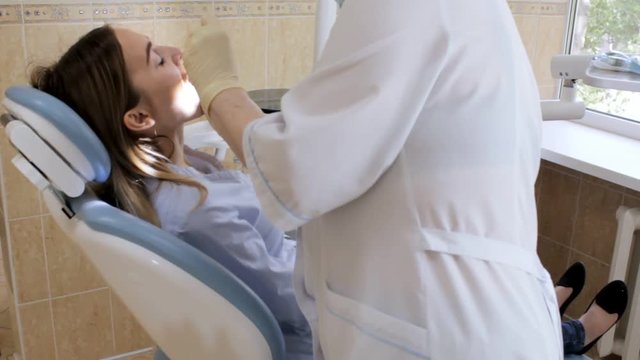 Dentist doctor checks patient's teeth tapping