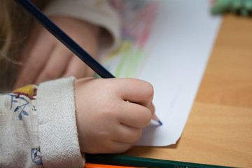 Kind malt und bastelt mit Buntstiften und Schere in Schule,Kindergarten und Hort