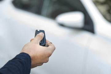 Young human hand is opening the car through the car key ..