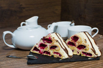 a teapot and a couple of cups with a cake on the table