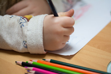 Kind malt und bastelt mit Buntstiften und Schere in Schule, Kindergarten und Hort