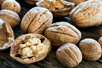 Closeup of whole and broken walnuts on old wood