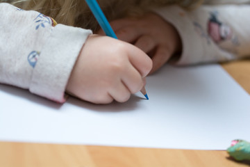 Kind malt und bastelt mit Buntstiften und Schere in Schule und Kindergarten