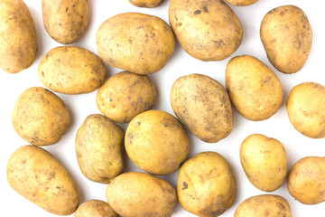 A lot of potatoes lie on a white background. View from above.
