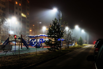 Illuminated playground late autumn evening.