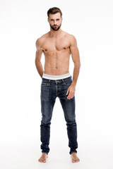 Fototapeta premium Shirtless and casual man. Full length of handsome young man in jeans looking at camera while standing against white background.