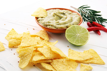 Bowl of guacamole with tortilla chips on white background
