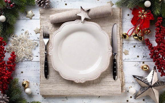 Christmas holiday dinner background; empty dish, cutlery and Christmas tree decoration
