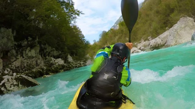 POV of kayaker paddling down the amazing blue river mastering the wave.
