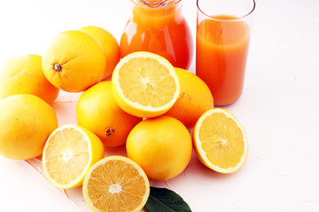 glass jar of fresh orange juice with fresh fruits on white table