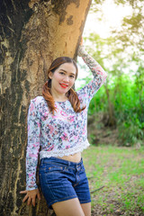 Portrait of thai woman sit under tree vivid tone style,Modern asian girl concept,lifestyle of happy woman