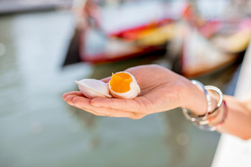 Holding portuguese delicacy called Ovos Moles made of egg yolks and sugar on the water channal...