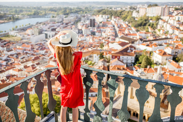 Young woman enjoying aerial view on the old town of Coimbra city during the sunset in the central Portugal