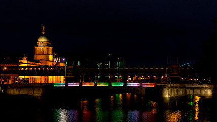 Fototapeta premium Cityscape by Night with Lit Bridge and Church