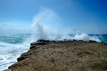Waves break about a stone pier