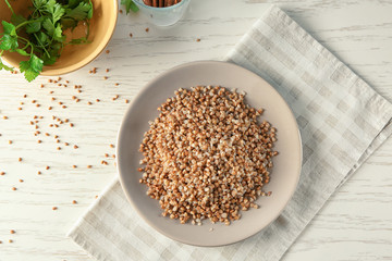 Plate with cooked buckwheat on table