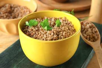 Bowl with cooked buckwheat on table