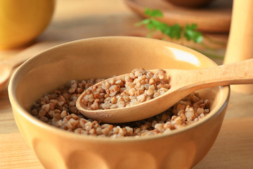 Bowl with cooked buckwheat on table