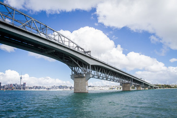 view of Auckland CBD, city center, with sky tower from under the bridge, new zealand