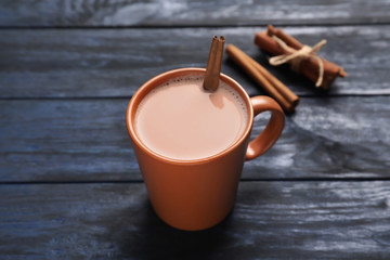 Mug with delicious cocoa drink on wooden background