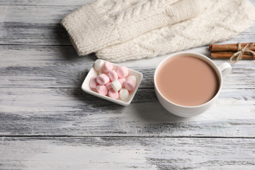 Cup with delicious cocoa drink on wooden background