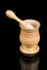 Wooden mortar isolated on black background with reflections