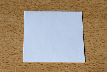 A white card on a wooden table