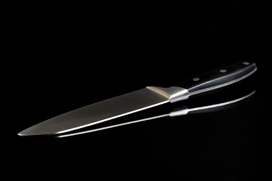 Chefs big kitchen knife isolated above black background with ref