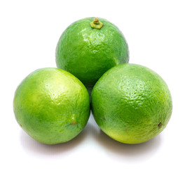 Three whole green limes isolated on white background.