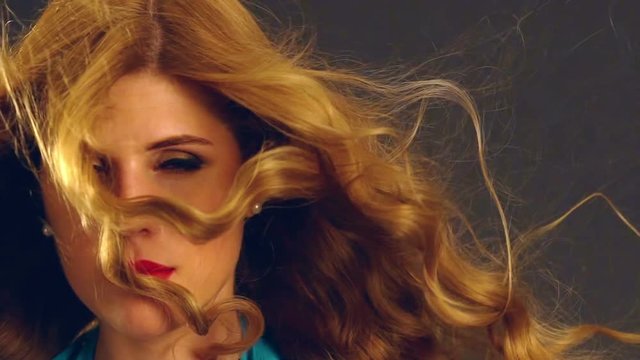 Blonde hair model on wind of beautiful blond girl with blowing hair in wind. Slow motion.