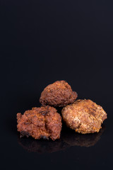 Meatballs isolated above black background with reflections and copy space