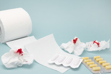 A photo of pills, used bloody toilet paper sheets, rectal candles and a tiolet paper roll....