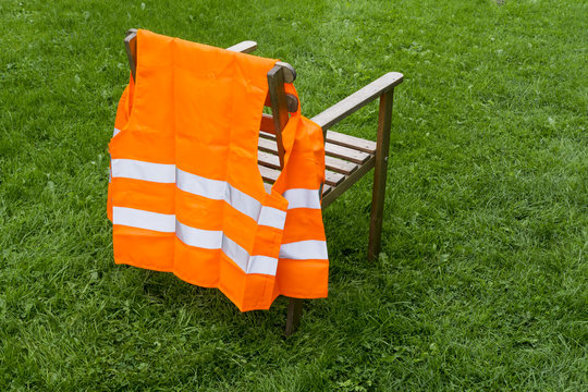 Chair With Orange Safety Vest On A Meadow