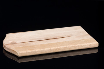 Kitchen wooden cutting board isolated above black background with reflections