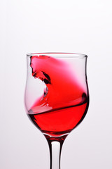 Glasses with waves plash of red wine on a white background