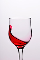 Glasses with waves plash of red wine on a white background