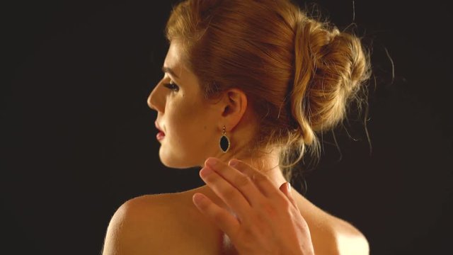 Woman neck and man hands helps girl to wear jewelery. Friend puts necklace on elegant lady. Romantic evening for loving couple on black background.