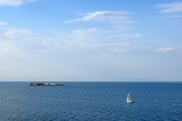 Fototapeta premium Seascape with sailing yacht and small island in sea