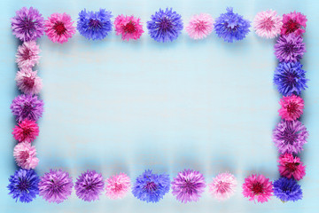 Flower frame of cornflowers on blue background