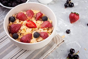 Cornflakes with berries on  grey background, fresh healthy  breakfast concept