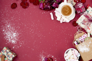 Naklejka premium Christmas gifts in bright boxes on a red background and coffee with marshmallows