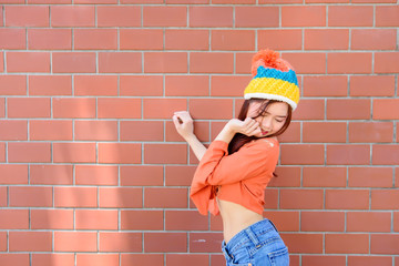 Asian hipsters girl on orange brick wall