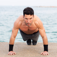 Obraz premium Athletic man with upper body free making push-ups exercise