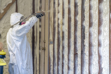 Worker spraying closed cell spray foam insulation on a home that was flooded by Hurricane Harvey