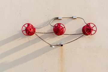 Red safety shutoff valves mounted on the outer wall of a building.