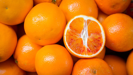Citrus fruits background. Fresh tangerines oranges on market. Group of freshly picked oranges with their leaves forming a background. Top view of slices, whole of orange fruits and leaves close up.