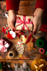 Hands of woman decorating Christmas gifts and decorations